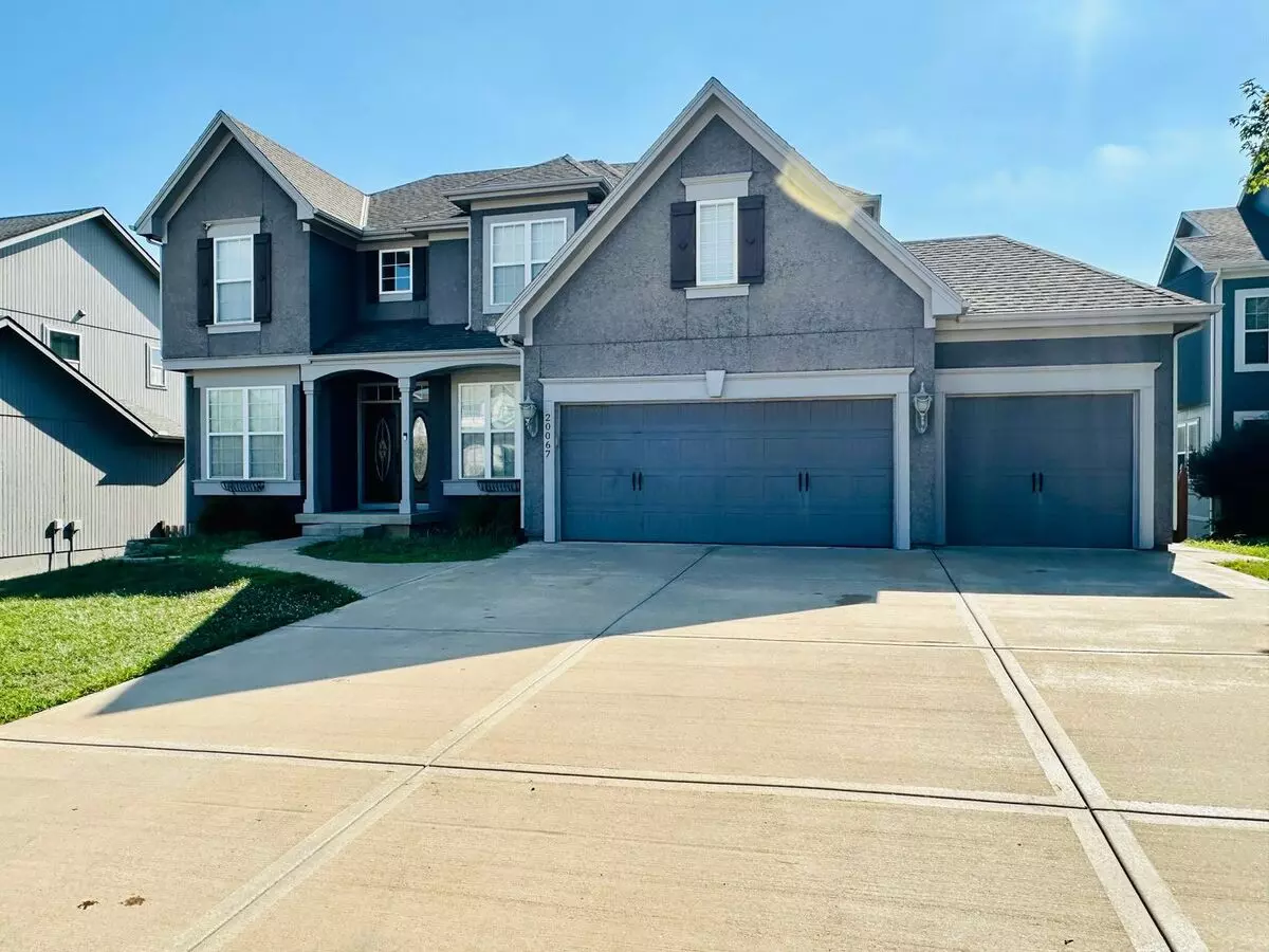 {20067} Custom Built Home In Woodland Manor + Open Main Level With Modern Lighting And Hardwood Flooring + Finished Walk Out Basement + Enclosed Sunroom + Three Car Garage + Fenced Yard House for rent in Olathe, KS